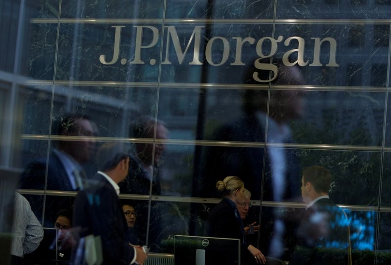 FILE PHOTO: Workers are reflected in the windows of the Canary Wharf offices of JP Morgan in London