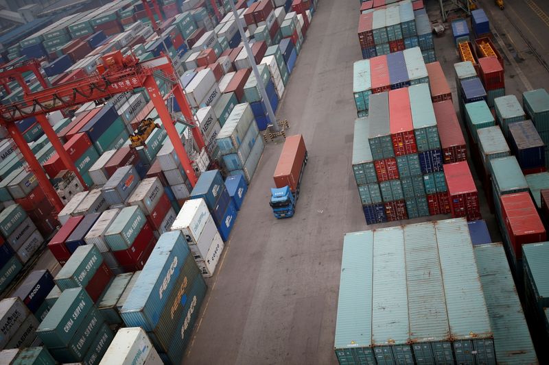 FILE PHOTO: A truck drives between shipping containers at a container terminal at Incheon port in Incheon