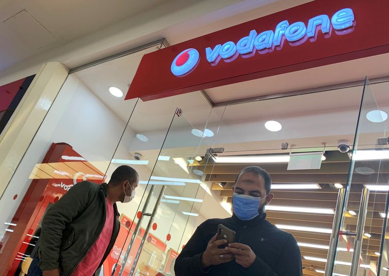 Shoppers wear protective face masks in front of a Vodafone store inside a City Centre mall ahead of Black Friday in Cairo