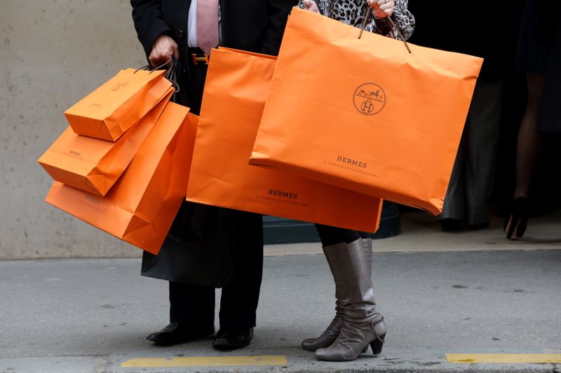 FILE PHOTO: A couple walk with Hermes shopping bags as they leave a Hermes store in Paris
