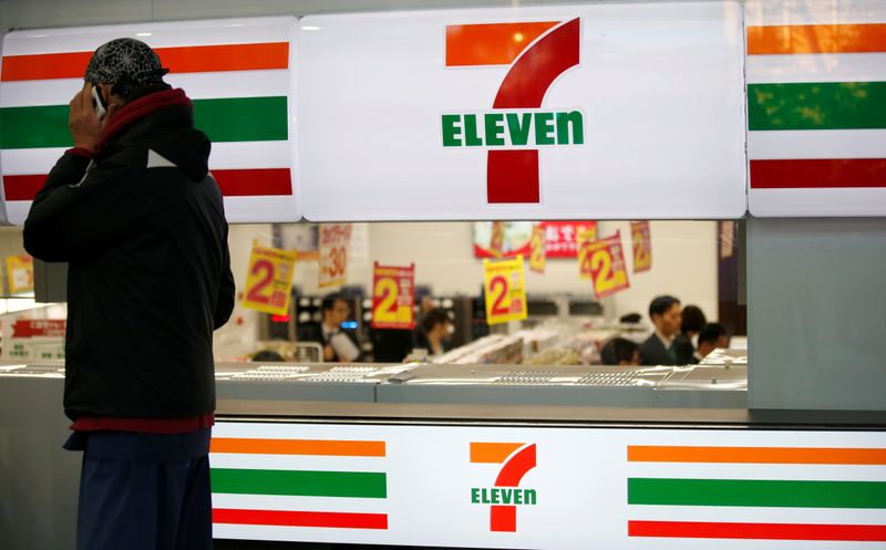 FILE PHOTO: A man uses a mobile phone outside a 7-Eleven convenience store in Tokyo