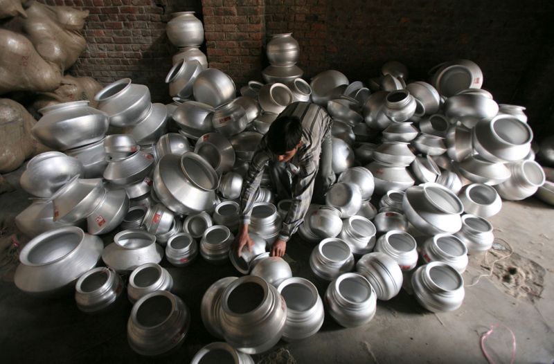 An employee works inside a stainless-steel utensil manufacturing unit on the outskirts of Jammu
