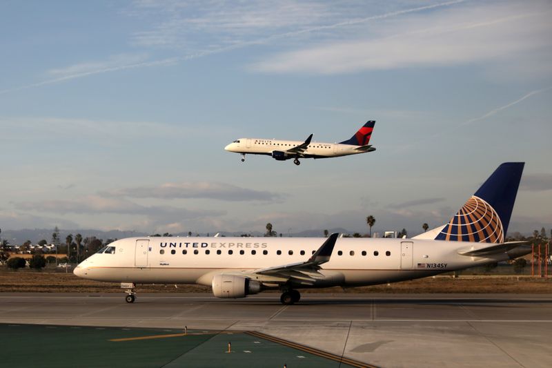 FILE PHOTO: A Delta Connection plane lands as a United Express plane waits to take off at LAX airport in Los Angeles