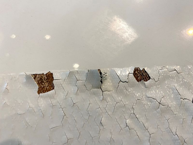 An undated image shows what appears to be paint peeling, cracking and exposed expanded copper foil (ECF) on the fuselage of a Qatar Airways A350 aircraft