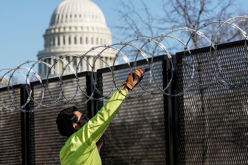 FILE PHOTO: Workers remove razor wire from security fencing near the U.S. Capitol in Washington
