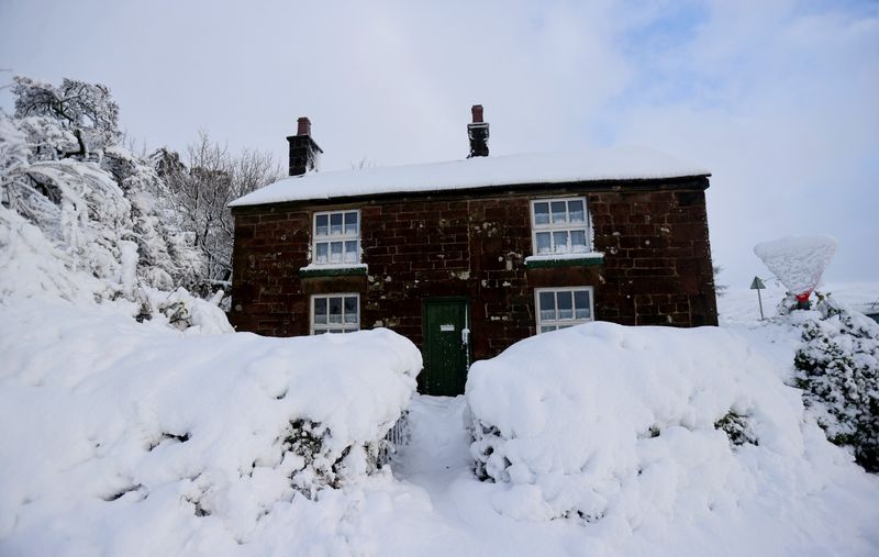 FILE PHOTO: A general view of a house that’s covered in snow that fell overnight from Storm Arwen, in Leek