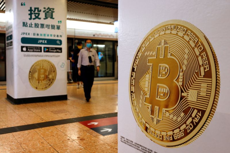 FILE PHOTO: Advertisements for crypto exchange shows a Bitcoin symbol at Mass Transit Railway (MTR) station, in Hong Kong