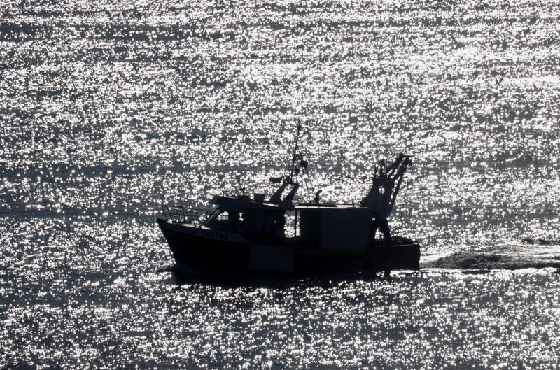A trawler sails off the fishing port in Granville