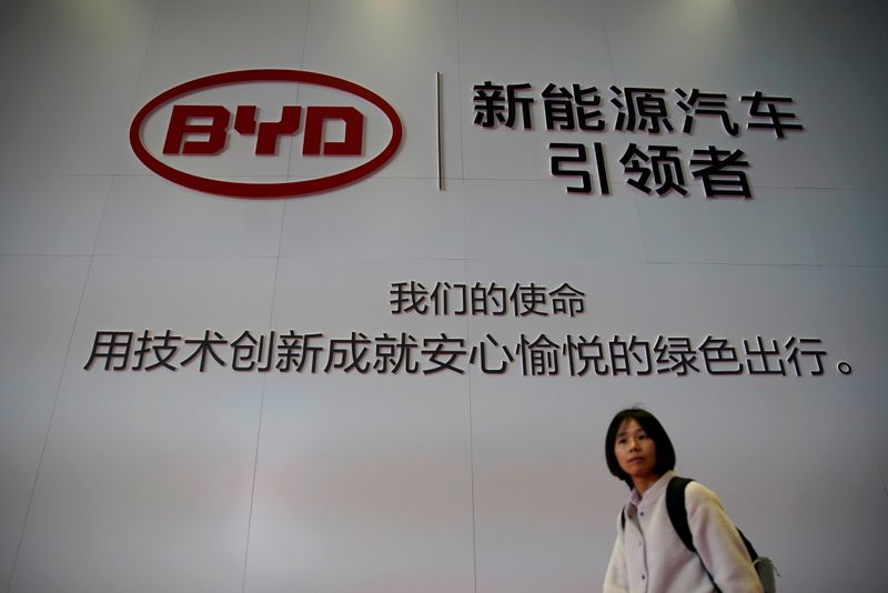 FILE PHOTO: Woman walks past a BYD sign at the second media day for the Shanghai auto show in Shanghai