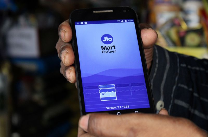 A shopkeeper selling consumer goods shows Reliance's JioMart Partner app on his mobile phone that he uses to order supplies for his store in Sangli