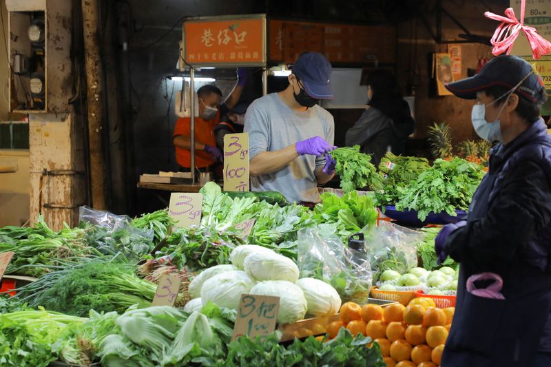 Man wearing a face mask to prevent the spread of the coronavirus disease (COVID-19) works at a stall in a market in Taipei