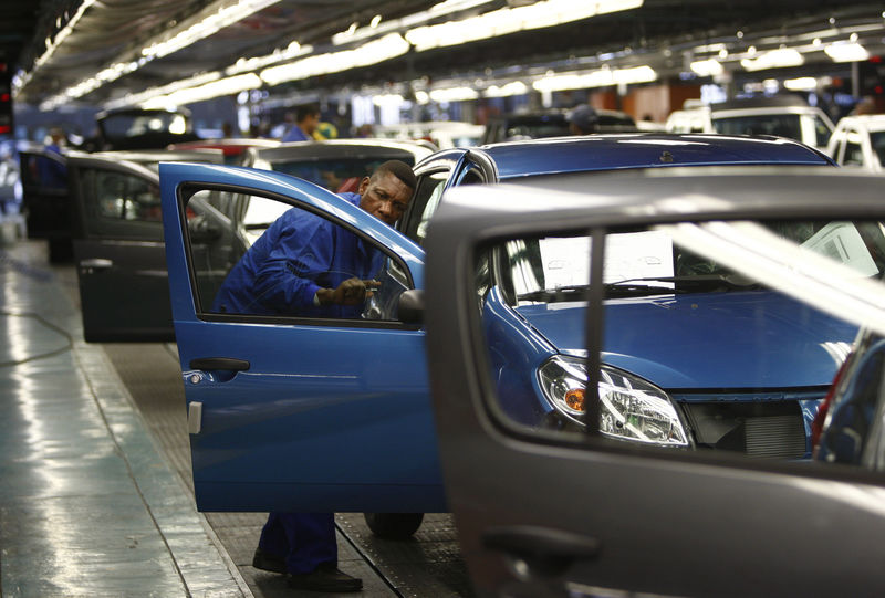 A worker inspects cars at Nissan's manufacturing plant in Rosslyn