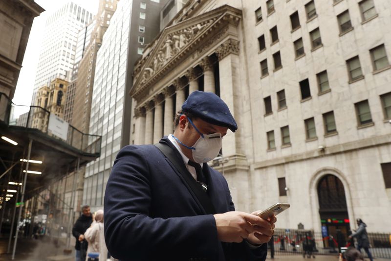FILE PHOTO: A man wears a protective mask as he walks on Wall Street during the coronavirus outbreak in New York