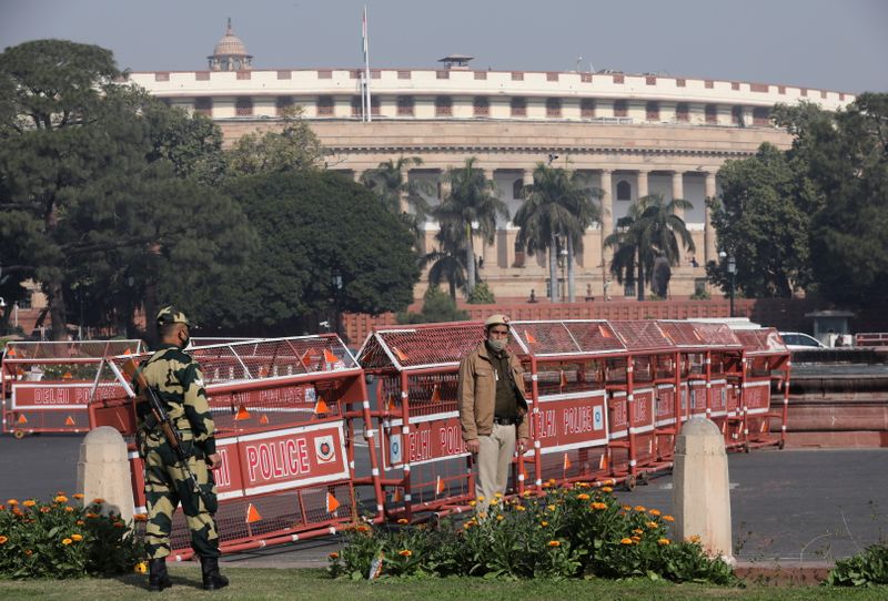 Security personnel stand guard next to barricades outside the Parliament where annual budget is being presented in New Delhi