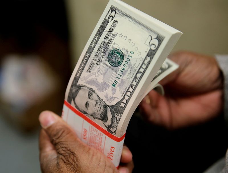 FILE PHOTO: A packet of U.S. five-dollar bills is inspected at the Bureau of Engraving and Printing in Washington