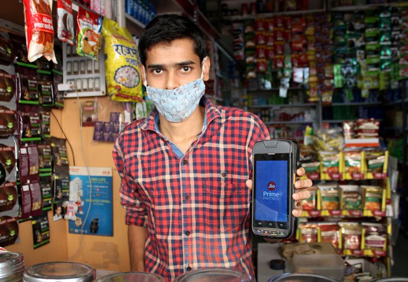 FILE PHOTO: A shopkeeper selling consumer goods displays Reliance's JioMart point-of-sale machine that he uses to order supplies for his store in Sangli