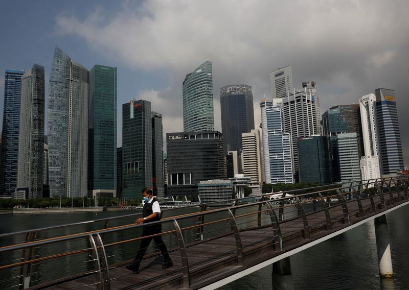 A man passes the city skyline during the coronavirus disease (COVID-19) outbreak, in Singapore
