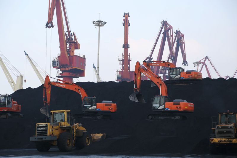 Workers operate loaders unloading imported coal at a port in Lianyungang, Jiangsu
