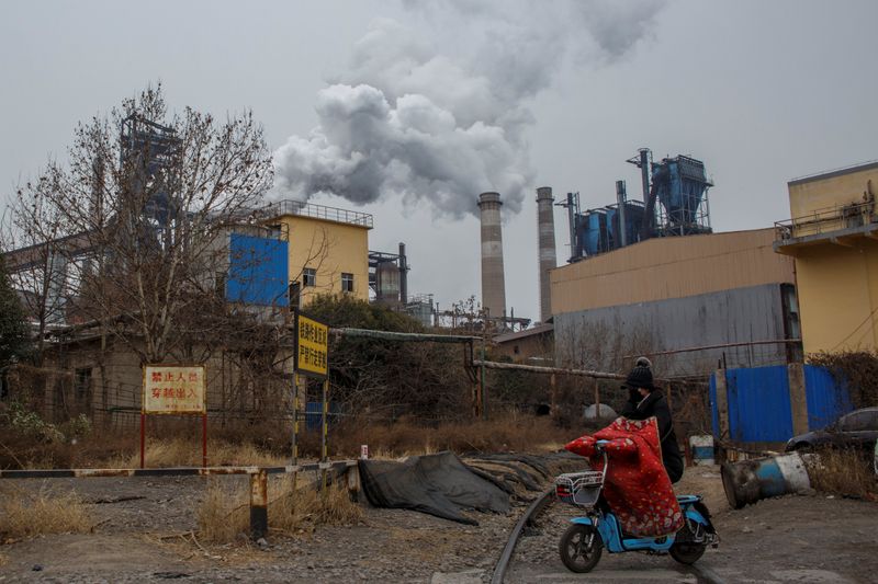 FOTO DE ARCHIVO: Una mujer frente a una planta de acero en Anyang, China