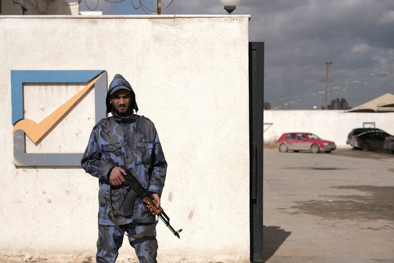 FILE PHOTO: A security officer stands in front of the High National Election Commission building in Benghazi