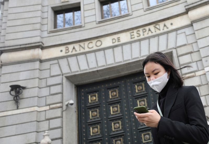 Woman wears a protective face mask as she walks past Banco de Espana (Bank of Spain), amidst concerns over coronavirus outbreak, in Barcelona