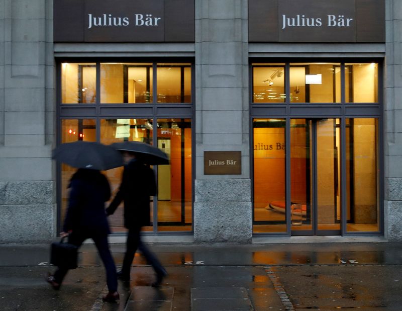 FILE PHOTO: People walk past a branch of Swiss bank Julius Baer in Zurich