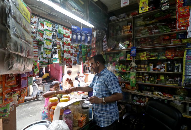 FILE PHOTO: Shivkumar Singh attends to a customer at his store in Dharavi, Mumbai