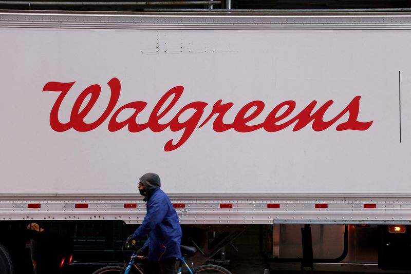 FILE PHOTO: A person rides past a Walgreens truck, owned by the Walgreens Boots Alliance, Inc., in Manhattan, New York City