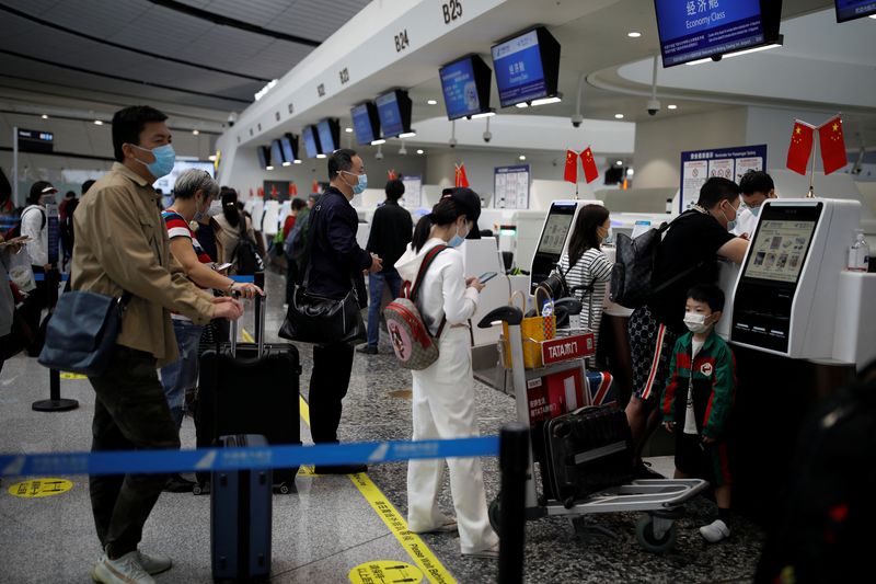 Passengers wearing face masks following the coronavirus disease (COVDI-19) outbreak line up to check in at the Beijing Daxing International Airport ahead of Chinese National Day holiday, in Beijing