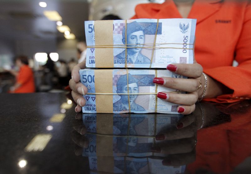 Teller prepares Indonesian rupiah for a customer at a money changer in Jakarta, Indonesia,