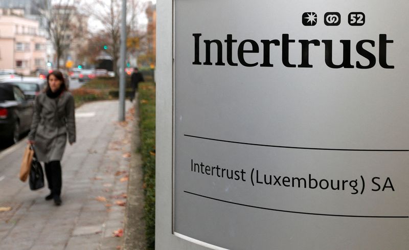 FILE PHOTO: A woman walks past the logo of Intertrust company in Luxembourg
