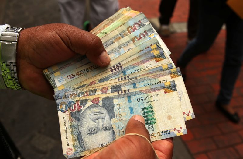FILE PHOTO: A money changer holds Peruvian Sol bills at a street in downtown Lima