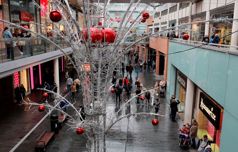 FILE PHOTO: People carry shopping bags as they look for bargains in the traditional Boxing Day sales in Liverpool