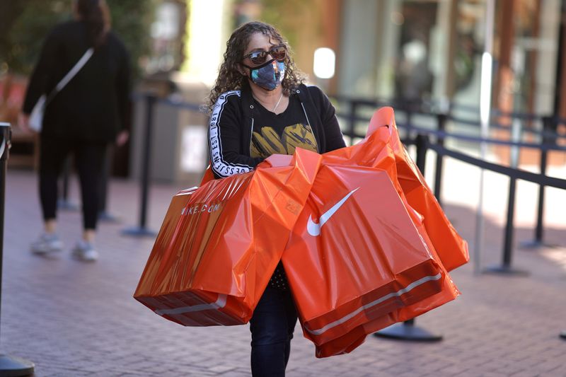 ARCHIV: Eine Frau mit Einkaufstaschen in der  Citadel Outlet Mall in Commerce, Kalifornien, USA, 3. Dezember 2020. REUTERS/Lucy Nicholson