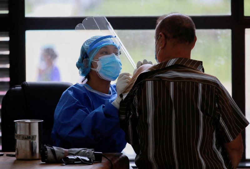 FOTO DE ARCHIVO: Una trabajadora sanitaria administra una dosis de la vacuna de COVID-19 a un hombre en Katmandú