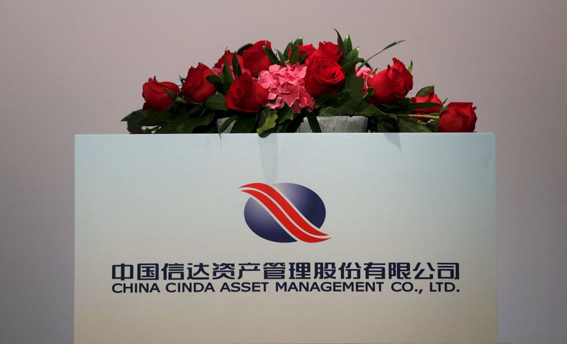 FILE PHOTO: The company logo of China Cinda Asset Management Co Ltd is displayed at a news conference on the company's annual results in Hong Kong