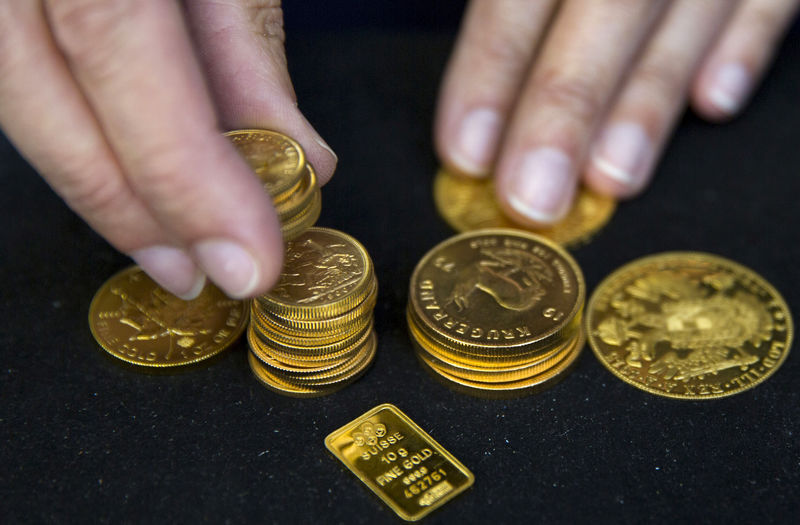 FILE PHOTO: A worker places gold bullion on display at Hatton Garden Metals precious metal dealers in London