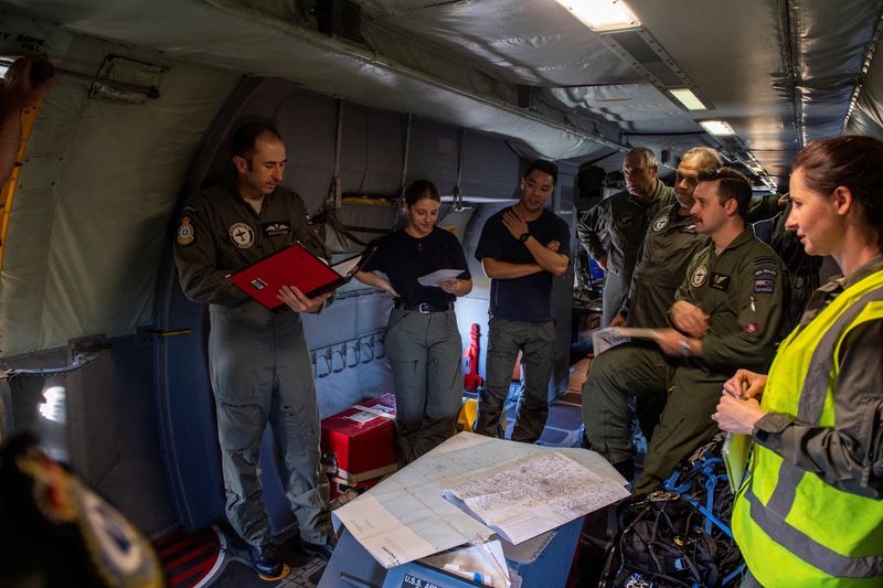 Aircrew work on board a New Zealand Air Force surveillance flight over Tonga