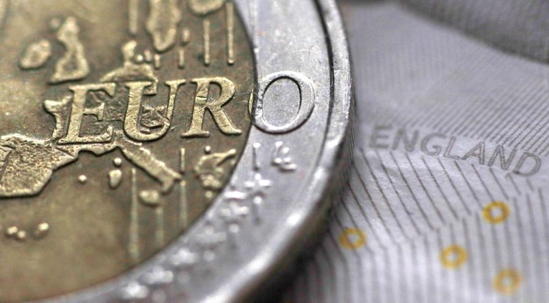 A two Euro coin is pictured next to an English ten Pound note in an illustration