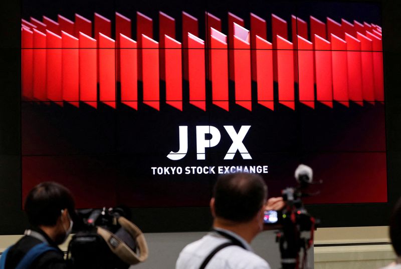 FILE PHOTO: TV camera men wait for the opening of market in front of a large screen showing stock prices at the Tokyo Stock Exchange in Tokyo