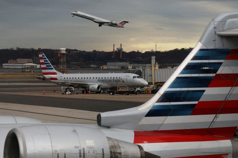 FILE PHOTO: A jet from American Eagle, a regional branch of American Airlines (AA), takes off past other AA aircraft at Ronald Reagan Washington National Airport in Arlington