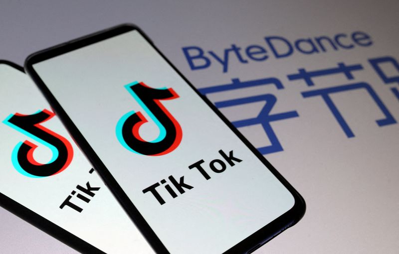 Imagen de archivo ilustrativa del logo de Tik Tok en pantallas de teléfonos inteligentes frente a una proyección del logo de ByteDance