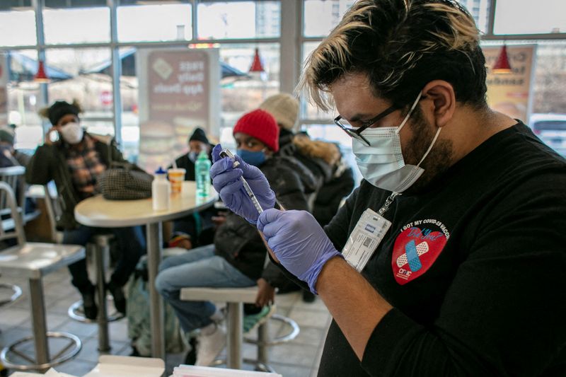 IMAGEN DE ARCHIVO REFERENCIAL. Un trabajador del Chicago Family Health Center prepara un refuerzo de la vacuna contra el COVID-19, en un McDonald's, en Chicago, EEUU