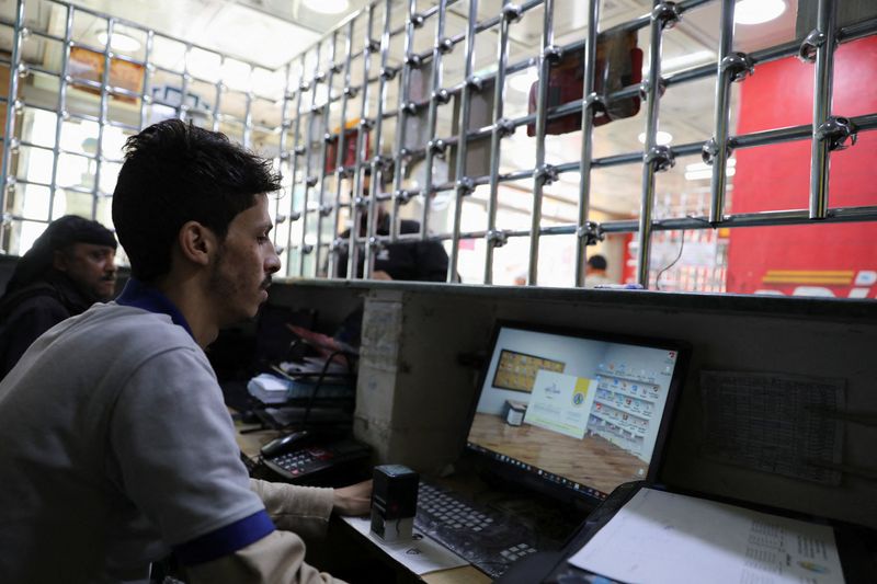 Cashiers at a money transfer company wait for customers amid an internet service cut in Sanaa