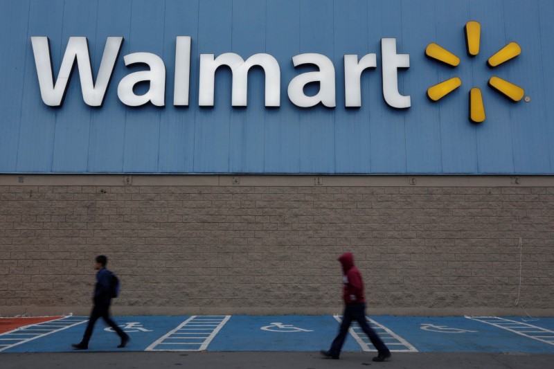 FILE PHOTO: Men walk past the logo of Walmart outside a store in Monterrey