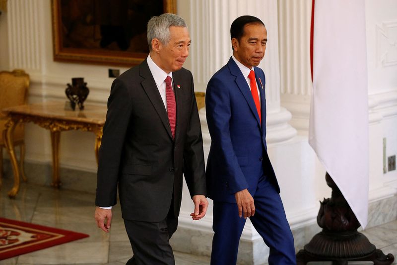 FILE PHOTO: Singapore's Prime Minister Lee Hsien Loong and Indonesian president Joko Widodo walk during their meeting ahead of the inauguration for the second term of Indonesian President Joko Widodo at the Presidential Palace in Jakarta