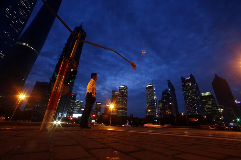 A man stands on the sidewalk at Pudong financial district in Shanghai