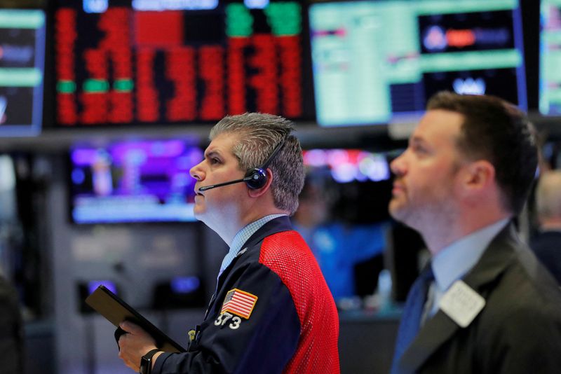 FILE PHOTO: Traders work on the floor of the New York Stock Exchange shortly after the opening bell as trading is halted in New York
