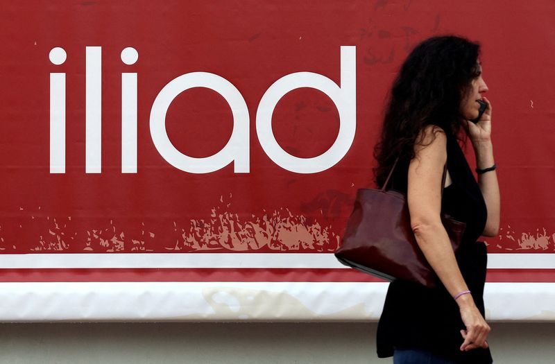 FILE PHOTO: A guest speaks on a mobile phone as she arrives for the French telecoms operator Iliad's media conference in Milan