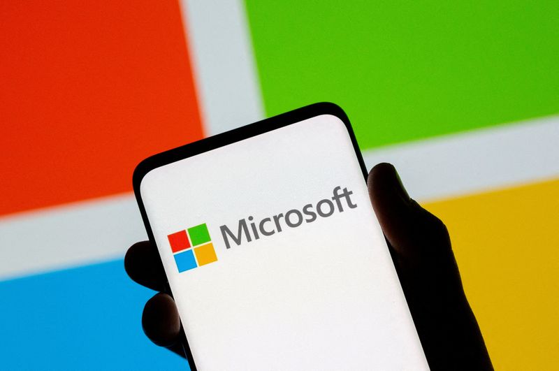FILE PHOTO: A smartphone is seen in front of the Microsoft logo in this illustration